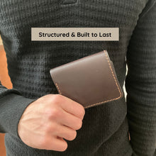 Load image into Gallery viewer, Person holding a brown leather wallet with text 'Structured & Built to Last' on a gray sweater.