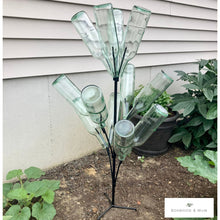 Load image into Gallery viewer, Bottle tree stand shown in the garden surrounded by plants. Holds 12 standard wine bottles.