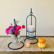Load image into Gallery viewer, Use the rustic metal hook stands as a Christmas or Thanksgiving centerpiece or as wedding table decor. Decorative setup with a black metal stand, flowers, candles, and pumpkins on a textured surface.