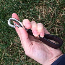 Load image into Gallery viewer, Leather keychain in a woman's hand showing the clasp being pushed open.