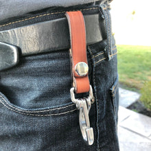 Load image into Gallery viewer, A light brown durable leather keyholder with a snap that is pictured on a man&#39;s belt.
