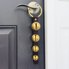 Load image into Gallery viewer, 4 solid brass sleigh bells on a front door knob hanging from a brass plated ring