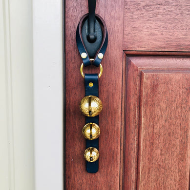 3 Solid Brass Sleigh Bells hanging on a front door handle