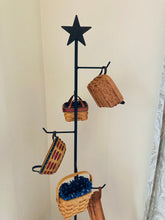 Load image into Gallery viewer, Up close picture of the rustic star at the top of the wrought iron basket tree