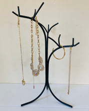 Load image into Gallery viewer, Close up picture of the black metal jewelry holder holding necklaces and a bracelet.