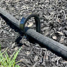 Load image into Gallery viewer, Hose running through a hose guide hook that pushed low in the ground.  Length of garden hooks is 17.75 inches which allows you to adjust the height of the stake in the ground.
