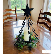 Load image into Gallery viewer, Christmas Tree Candle Stand shown as table centerpiece and holds a white pillar candle that is surrounded by holiday greenery.  (Candle and greenery are not included.  This listing is for the Christmas Tree Candle Holder only).
