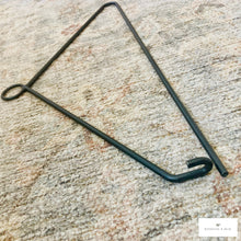 Load image into Gallery viewer, Black metal quilt hanger wall hook on a textured beige surface
