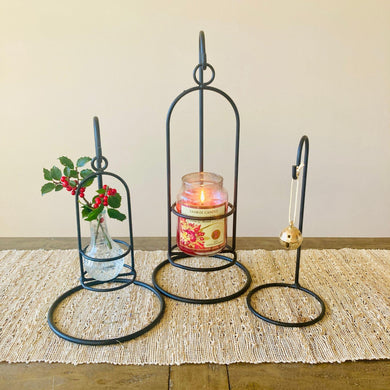 Amish handmade wrought iron countertop hook stand with candle. Set of three decorative candle holders on a wooden surface with a neutral background. 