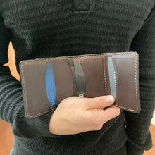 Load image into Gallery viewer, Person holding a brown wallet with visible brand name
