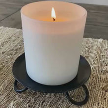 Load and play video in Gallery viewer, Video starting with a close up view of the black metal pillar candle stand then video zooms out to show the pair sitting on a wooden table with a vase of flowers in the middle.
