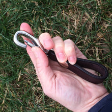 Load image into Gallery viewer, Leather keychain in a woman&#39;s hand showing the clasp being pushed open.
