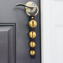 Load image into Gallery viewer, 4 solid brass sleigh bells on a front door knob hanging from a brass plated ring
