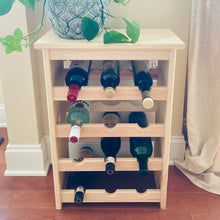 Load image into Gallery viewer, Wine rack free standing on a hardwood floor and holding 7 wine bottles.  Green plant is placed on top of rustic wine rack
