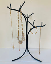 Load image into Gallery viewer, Close up picture of the black metal jewelry holder holding necklaces and a bracelet.  
