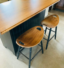 Load image into Gallery viewer, Two saddle stools pushed uner a kitchen island overhang.
